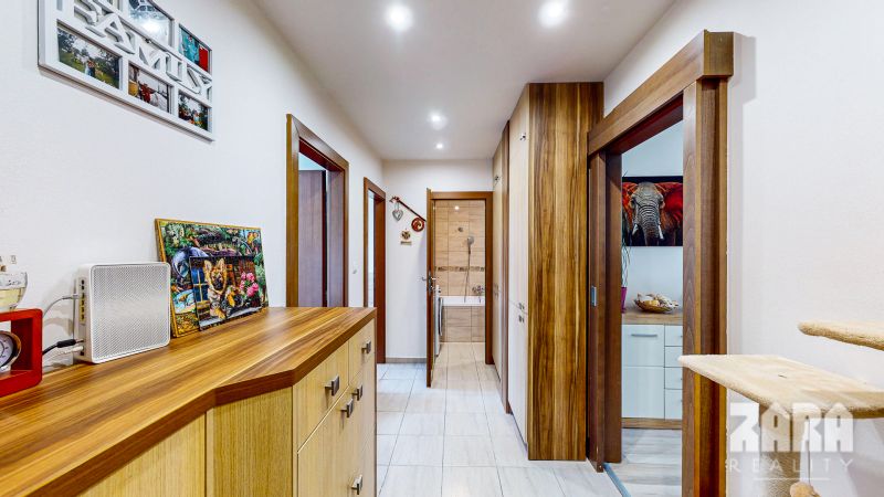 A hallway in a 3-room apartment with a wooden decor floor and built-in wardrobes.