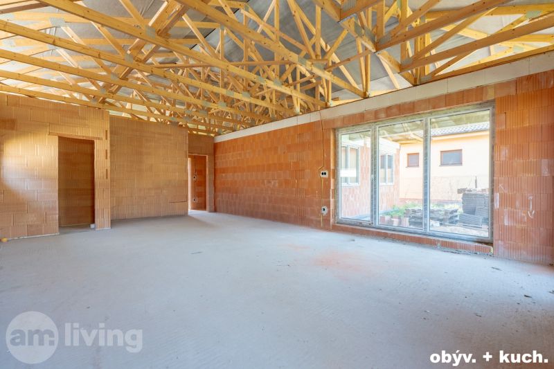 Unfinished interior with exposed ceiling and large windows in a family house.
