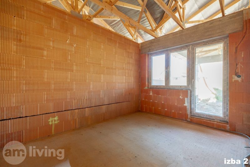 A room in a family house with brick walls and a raw floor.