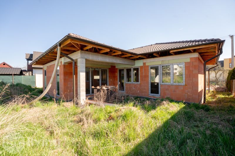 A family house in Drietoma with an unmaintained garden and an unfinished facade.
