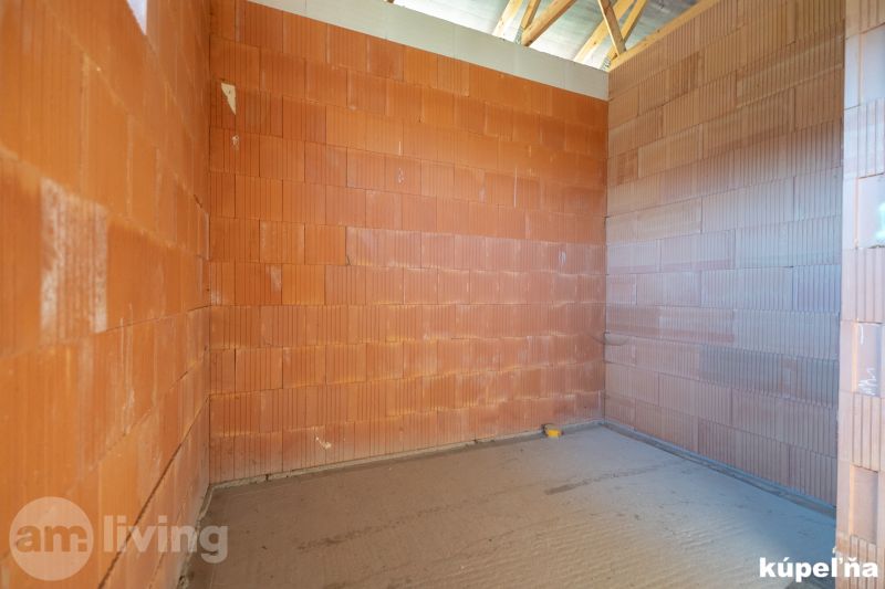 An unplastered wall in the interior of a family house bathroom with brick blocks.