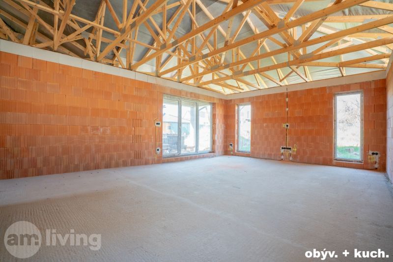 A spacious room in a family house with brick walls and wooden beams.