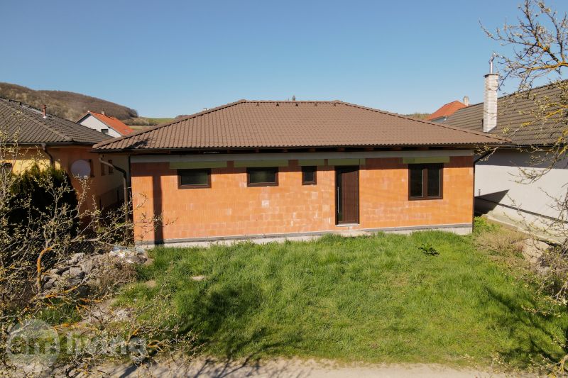 A family house in Drietoma with a brown tile roof and a brick facade.