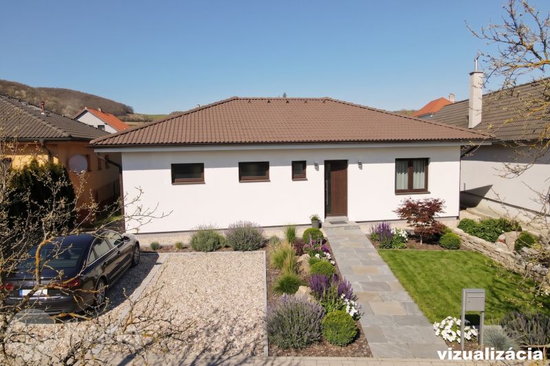 A family house in the village of Drietoma with a well-maintained garden and driveway.