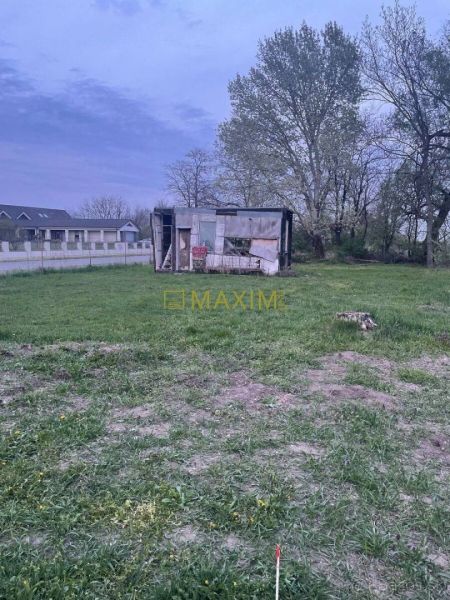 Plots - residential in the village of Slovenská Nová Ves with an old building and grassy vegetation.