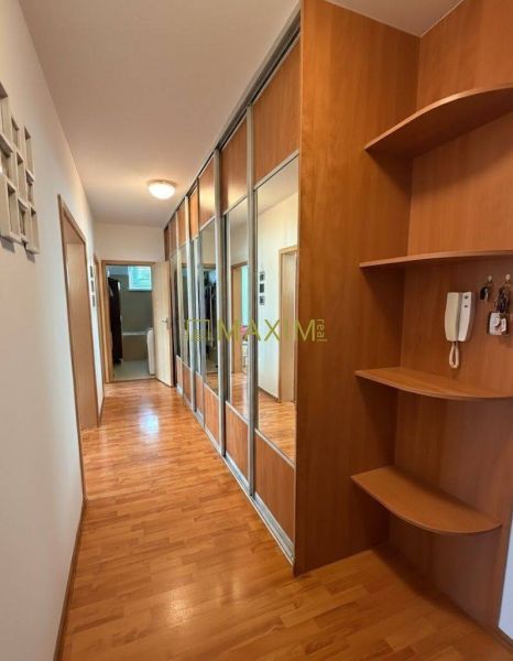 A hallway with a built-in wardrobe and shelves, a floor with a wood decor, a 2-room apartment.