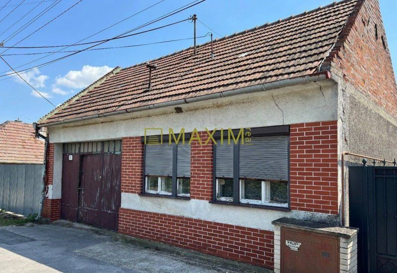 A family house in Dolné Orešany with a sloped roof and brick cladding on the facade.