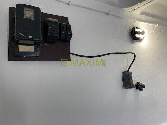 An electrical panel on the garage wall, a light on the wall.