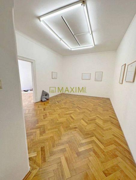 A room in a 3-room apartment with a wood-patterned floor and white walls.