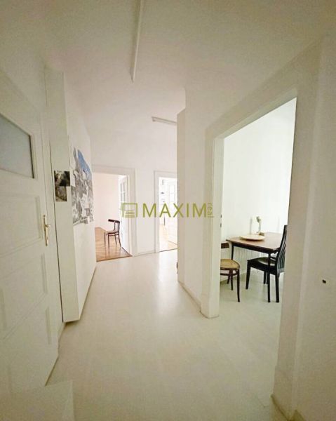 A hallway of a 3-room apartment with a light floor and built-in furniture.