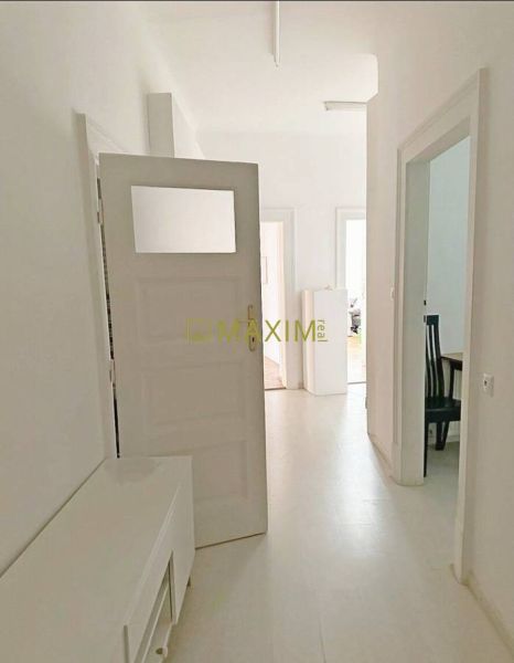 A bright hallway in a 3-room apartment with white walls and furniture.