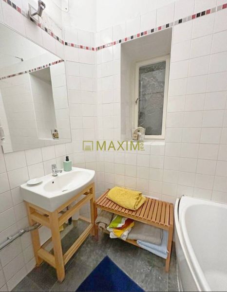 A bathroom in a 3-room apartment with a sink, bathtub, and storage space.