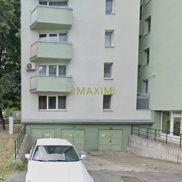 Building and garages in Bratislava - Ružinov on Ružová dolina, white car parked in the foreground.