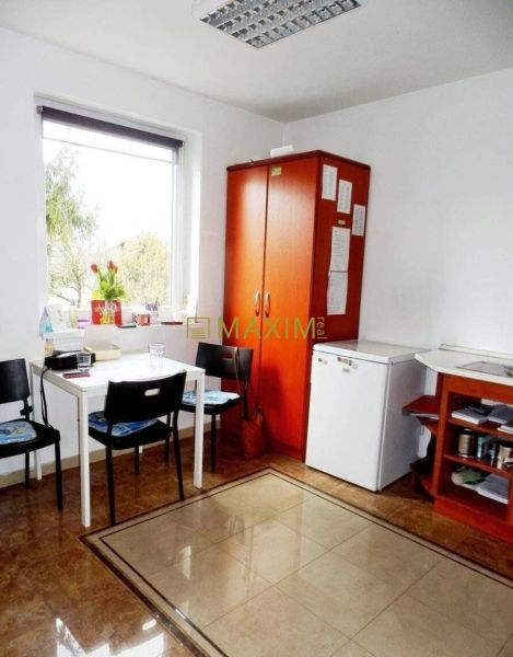 A kitchenette with wooden decor, a table, chairs, and a refrigerator in a cabin.
