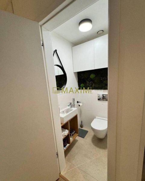 Bathroom with a mirror, sink, and toilet in a 3-room apartment.
