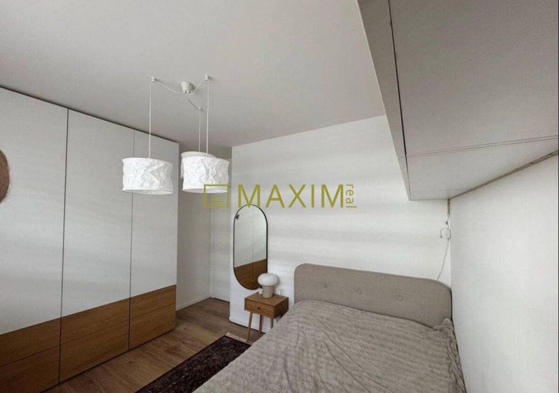 Bedroom in a 3-room apartment with wood-decor flooring, a mirror, and a wardrobe.