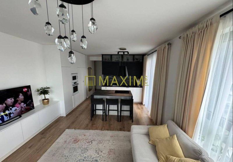Living room of a three-room apartment with a kitchen, lighting, and flooring with a wooden decor.