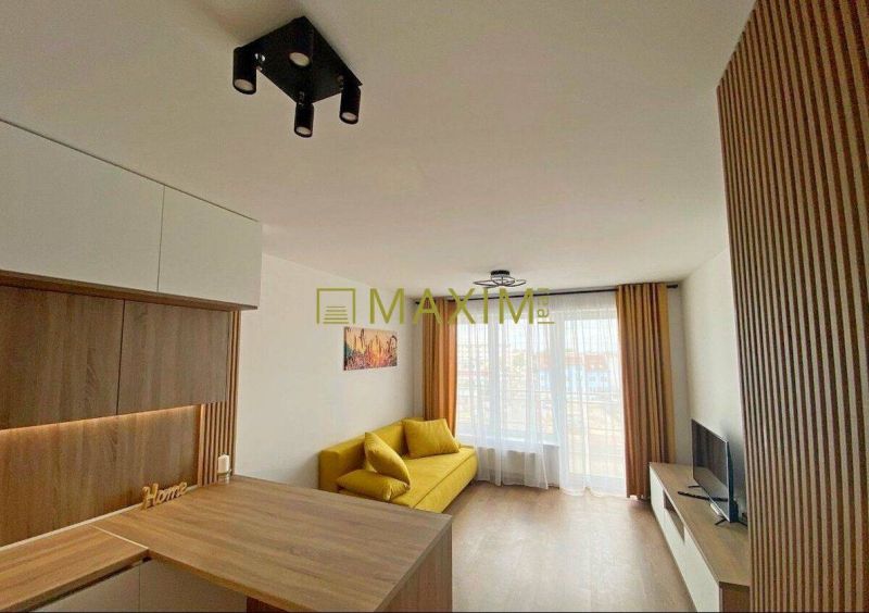 Living room with wood-patterned flooring, a yellow sofa, and modern lighting in a two-room apartment.