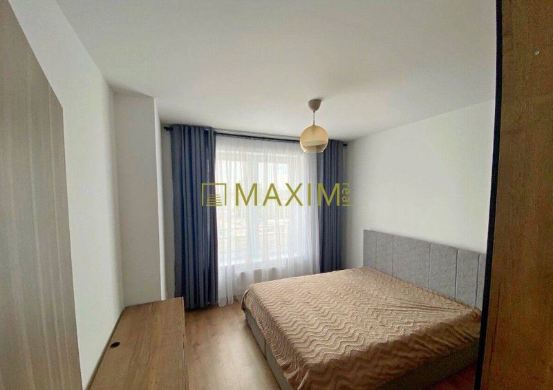 Bedroom in a 2-room apartment with a bed and a wooden decor floor.