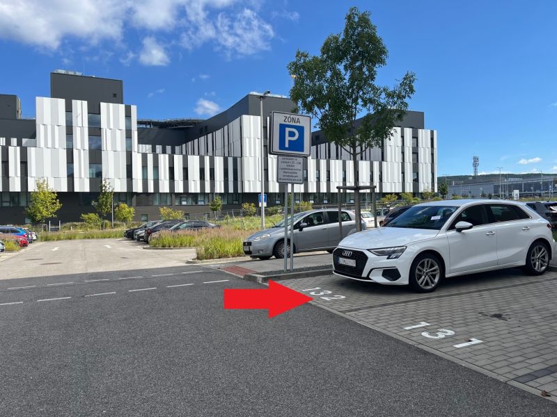 Parking lot with a parking zone sign and a modern building in Bratislava - Lamač.
