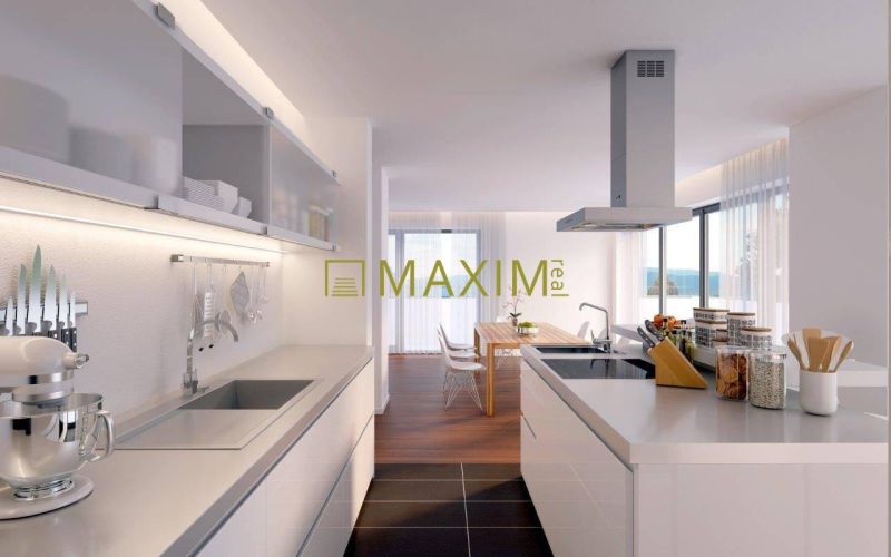 A kitchen in a 2-room apartment with a wooden decor floor and a dining table.