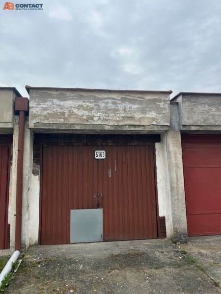 Garages on Dopravná Street in Piešťany with a worn-out gate and gray facade.