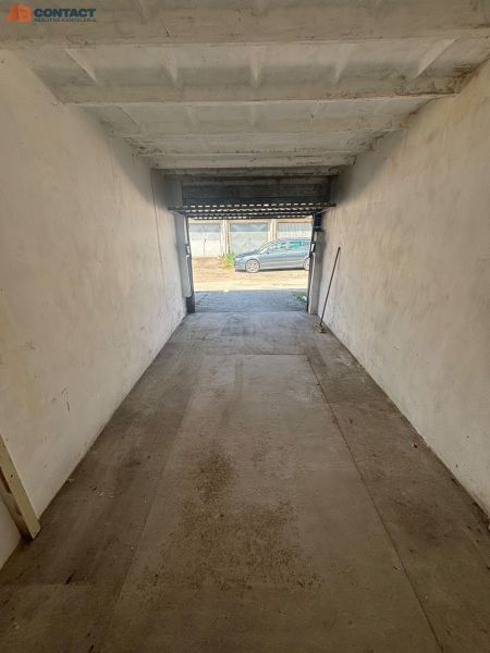 A garage with open doors on Dopravná Street in Piešťany, concrete floor.