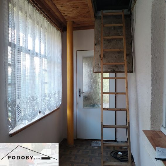 Interior of a family house with a wooden decor floor, stairs, and curtains.