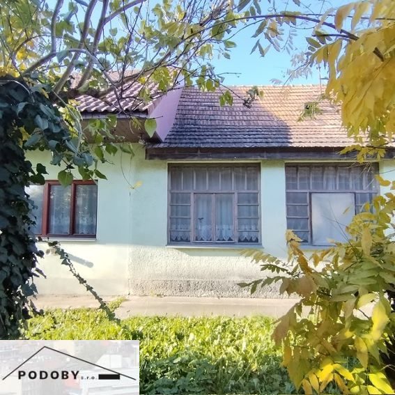 A family house in Veľké Úľany with a front garden, surrounded by greenery and sunlight.