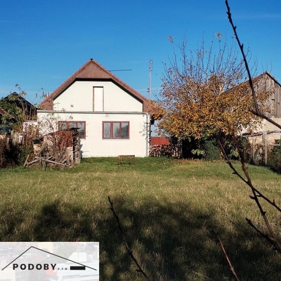 A family house in Veľké Úľany with a garden and greenery under a blue sky.