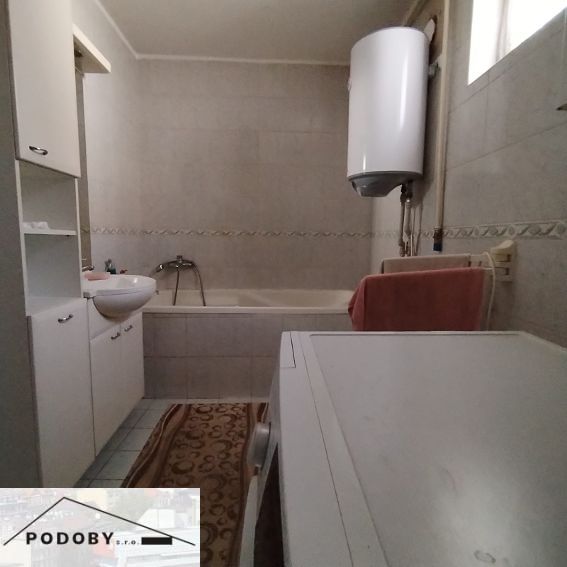 Bathroom in a family house with a bathtub, sink, and washing machine.