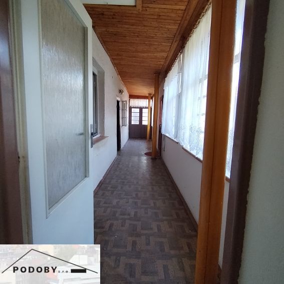 A hallway with a wooden decor floor in a family house.