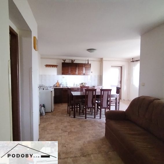 Living room with a kitchenette and a wooden decor floor in a family house.