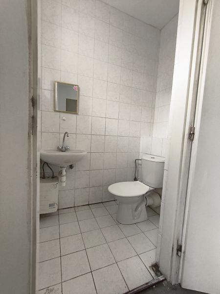 A restroom with white tiles in commercial premises.