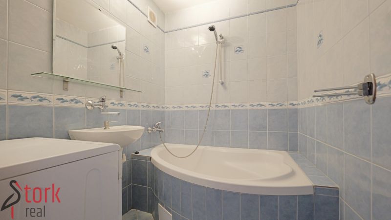 Bathroom in a 3-room apartment with tiles and a bathtub with a sink.