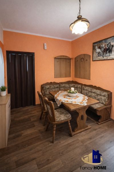 Dining area with a sofa set and table, floor with wooden decor.