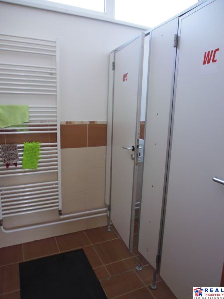 Toilet with radiator and cubicles in commercial premises.