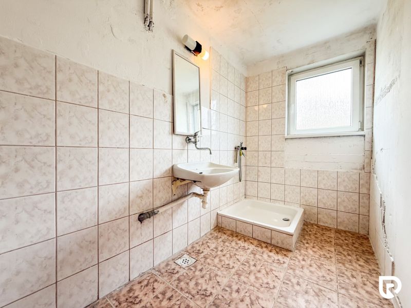 A bathroom with a shower cabin tiled in a 3-room apartment.