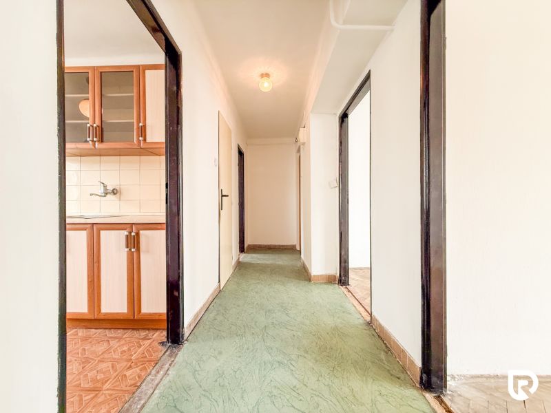 A hallway with linoleum, wooden decor in the kitchen, 3-room apartment.