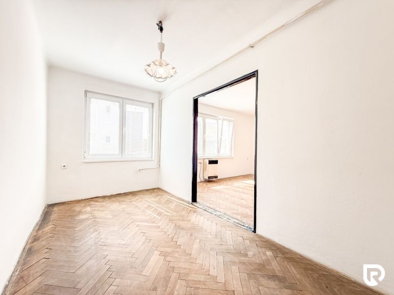 A room with a wooden decor floor in a 3-room apartment.