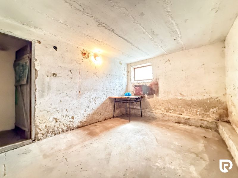 The room is dominated by a table, a window, and lighting on the wall.