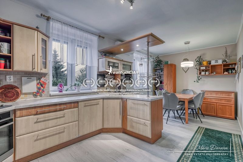 A kitchen in a family house with a wooden decor floor, equipped with kitchen furniture.