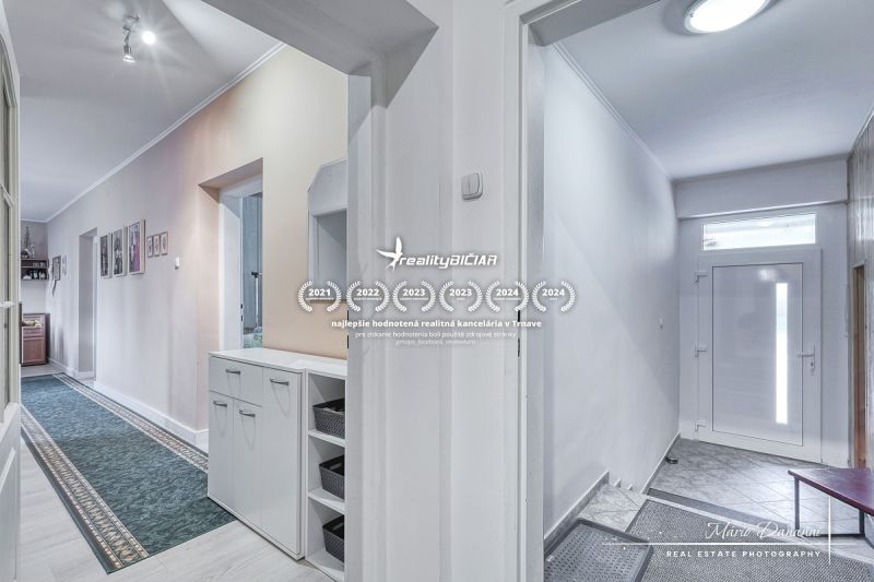 A hallway in a family house with white walls and practical storage space.
