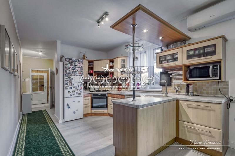 A kitchen in a family house with a wooden decor floor, appliances, and equipment.