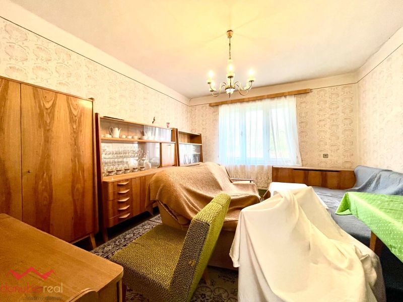 Living room in a family house with retro furniture and patterned wallpaper.