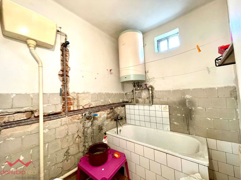 A bathroom in a family house with tiles and a white boiler.