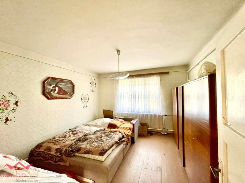 Bedroom interior in a family house with a bed and wooden floor decor.