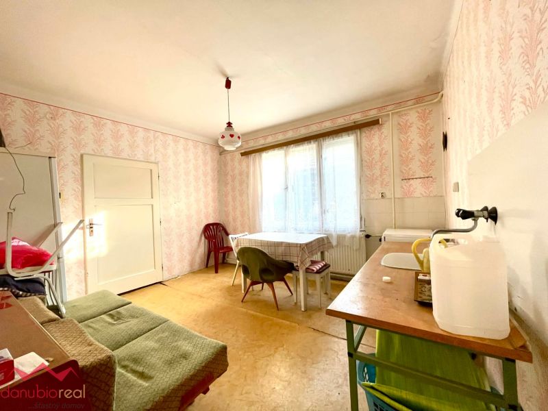 Dining room with vintage wallpaper and simple furniture in a family house.