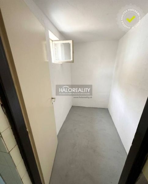 Laundry room in a family house with white walls and a small window.