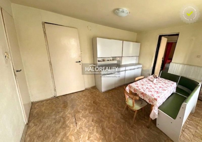 A dining room in a family house with a corner bench, a floor with a wooden decor, and cabinets.